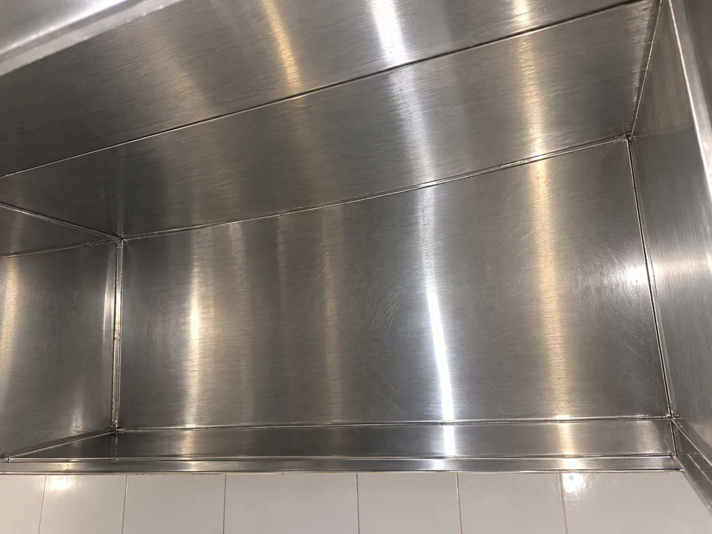 Busy takeaway kitchen with cooking equipment under an extraction canopy